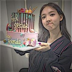 a woman holding a plate with a pink cake on it and the words friends written on it