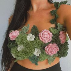 a woman wearing a crop top with crocheted flowers on it