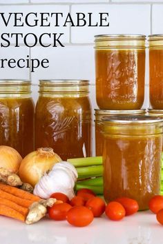 several jars filled with vegetables sitting on top of a counter next to garlic, carrots and celery