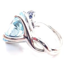 Chanel Camellia Flower 18k White Gold Aquamarine Sapphire Ring       Metal: 18k white gold  Size: European 48 US 4.5  Weight: 13.8 grams  Width: 16mm  Stones: One round large aquamarine 15mm 35 round blue sapphires  Hallmarks: CHANEL 750 48 17L523  Dimensions reference the ring size and are not specific to the ring itself. Luxury Light Blue Round Ring, Luxury Light Blue Round Rings, Chanel Camellia Flower, Chanel Camellia, Camellia Flower, Ring Metal, Metal Rings, Aquamarine, Blue Sapphire