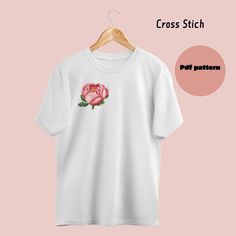 a white t - shirt with a pink rose embroidered on the front and back side