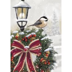 a bird sitting on top of a christmas wreath next to a street light with a red bow