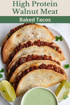 some tacos are on a white plate next to a small bowl of green sauce