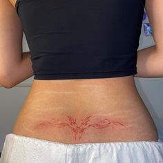 the back of a woman's stomach with a tattoo design on her lower body