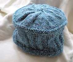 a blue knitted hat sitting on top of a bed