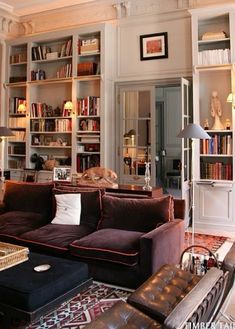 a living room filled with lots of furniture and bookshelves full of bookcases