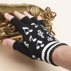 a person is holding up a musical instrument with music notes on it and gold bells in the background