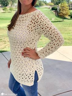 a woman is posing for the camera wearing a white crochet sweater