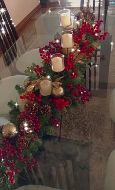 a table with candles and christmas decorations on it in the middle of a room filled with chairs