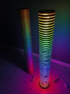 two tall vases sitting on top of a floor in front of a neon colored wall