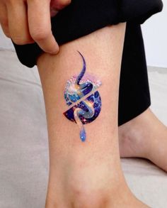 a woman's foot with a tattoo design on the left side of her leg