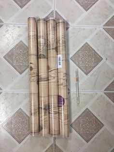 three rolls of wrapping paper sitting on top of a tile floor