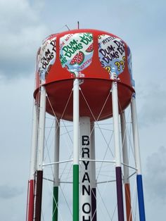 a large red water tower with graffiti on it's side and the words bravo dunkin donuts painted all over it