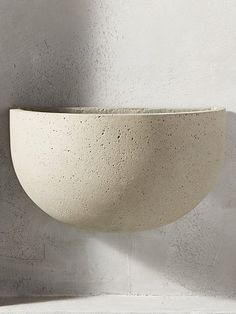 a white bowl sitting on top of a wall