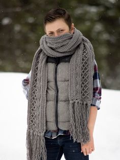 a woman standing in the snow wearing a scarf