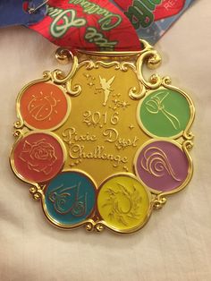 a gold medal with colorful ribbons around it