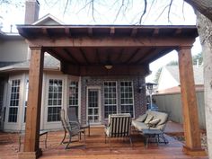 an outdoor covered patio with chairs and table