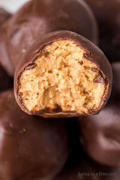 chocolate covered peanut butter balls stacked on top of each other with the bite taken out