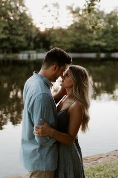 a man and woman standing next to each other near water