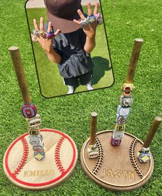 two baseball trophies sitting on top of a field next to each other with the name and number engraved on them