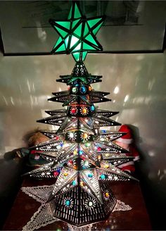 a lighted christmas tree sitting on top of a wooden table