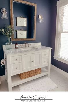 a white bathroom vanity with blue walls and a large mirror over it's sink