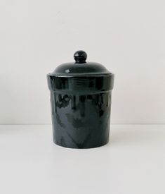 a black ceramic container sitting on top of a white table