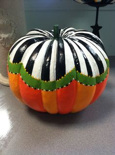 a striped pumpkin sitting on top of a table