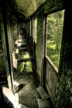 the inside of an abandoned train car with lots of windows and stairs leading up to it