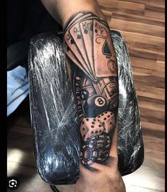 a man's arm with playing cards and dice tattoo on his left arm,