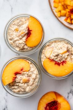 four jars filled with oatmeal and peaches on top of a table