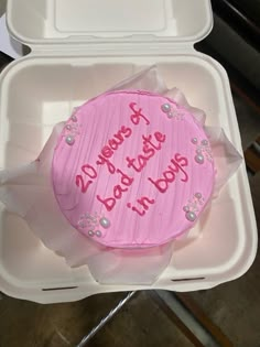 a pink frosted birthday cake in a foam container with writing on the top and bottom