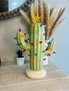 a cactus is sitting on a table next to a mirror