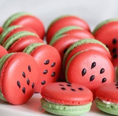 there are many red and green macaroons on the plate