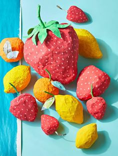 some strawberries, oranges and lemons are on a blue surface with white polka dots