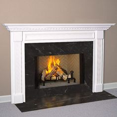 a white fireplace with a fire in it