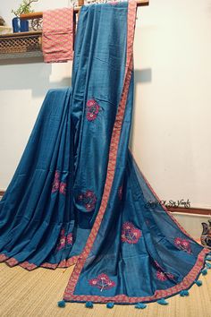 This blue handloom soft cotton saree is a true embodiment of style meeting comfort. With its beautiful floral motif embroidery, neatly done, and the addition of a printed border and tassels, it becomes a captivating and unique piece. The inclusion of both a running blouse piece and a matching cotton printed blouse piece adds further flexibility, allowing you to showcase your style effortlessly in any occasion. Details: Blouse: Yes. With matching printed cotton Blouse Piece Fabric: Handloom soft cotton saree Work: Machine Embroidery work [* This work is neither Computerized Machine Embroidery work nor machine Aari Embroidery with woolen thread. * It's completely Manual Machine Embroidery Work with silk threads..] Saree length:  6.3 mtrs Saree width: 45 inches Fall & Picot: You do not need a Blue Floral Embroidered Traditional Wear In Mulmul, Blue Mulmul Traditional Wear With Floral Embroidery, Blue Cotton Silk Dupatta With Embroidered Border, Bohemian Cotton Semi-stitched Saree, Semi-stitched Bohemian Cotton Saree, Bohemian Semi-stitched Cotton Saree, Blue Embroidered Cotton Silk Dupatta, Cotton Silk Saree With Embroidered Border, Blue Blouse Piece With Embroidered Border For Festivals