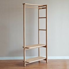 a wooden shelf sitting on top of a hard wood floor next to a white wall