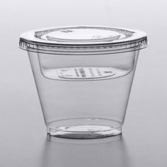 a clear plastic container with a lid on a reflective surface, filled with water or liquid