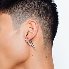 a close up of a person with ear piercings on their ears and behind them is a man's head