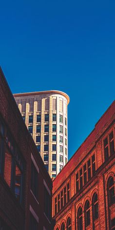 the building is tall and has many windows on each side, along with other buildings