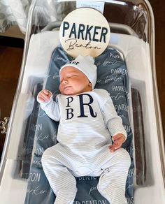 a baby doll is laying in a plastic box with the name parker written on it