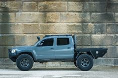 a grey truck parked in front of a brick wall