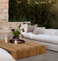 an outdoor living area with white couches and candles