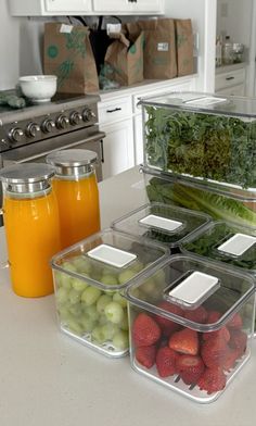 several containers filled with fruits and vegetables sitting on a kitchen counter next to an oven