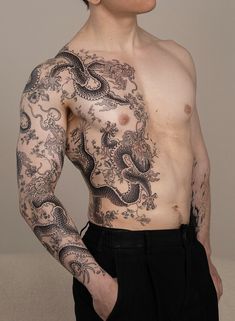 a shirtless man with tattoos on his chest and arms is posing for the camera