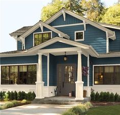 a gray house with white trim and pillars