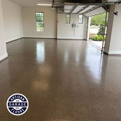 an empty garage with no one inside or outside the door, and there is a logo on the floor