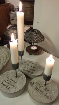 three candles are lit on some stone coasters