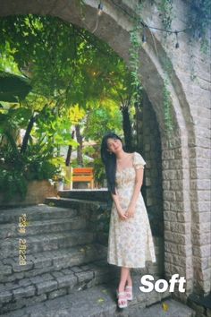 a woman in a white dress standing on some steps